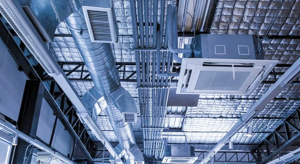 Exposed ductwork, piping, and HVAC systems in a building mechanical ceiling