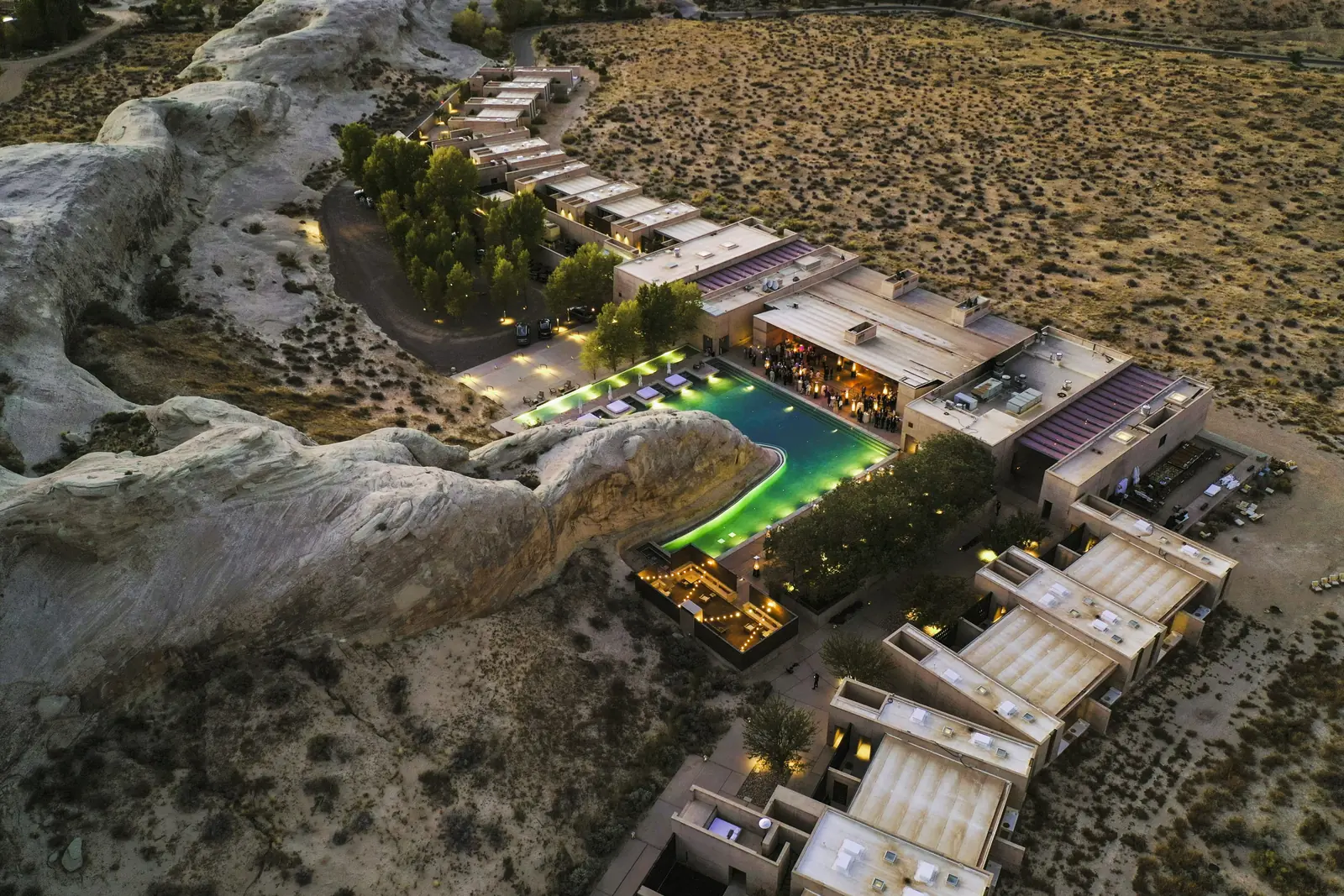 Dusk aerial of a desert resort development set into red rock terrain